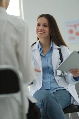 Doktor ve hasta masada otururken bir şey tartışıyorlar. İlaç ve sağlık hizmetleri kavramı