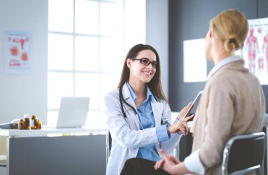 Doktor ve hasta masada otururken bir şey tartışıyorlar. İlaç ve sağlık hizmetleri kavramı