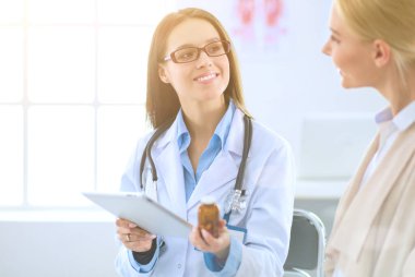 Doktor ve hasta masada otururken bir şey tartışıyorlar. İlaç ve sağlık hizmetleri kavramı