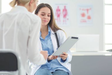 Doktor ve hasta masada otururken bir şey tartışıyorlar. İlaç ve sağlık hizmetleri kavramı