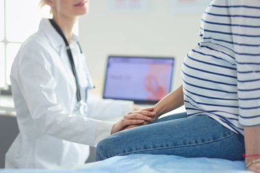 Hastanede doktorla gülümseyen güzel bir hamile kadın.