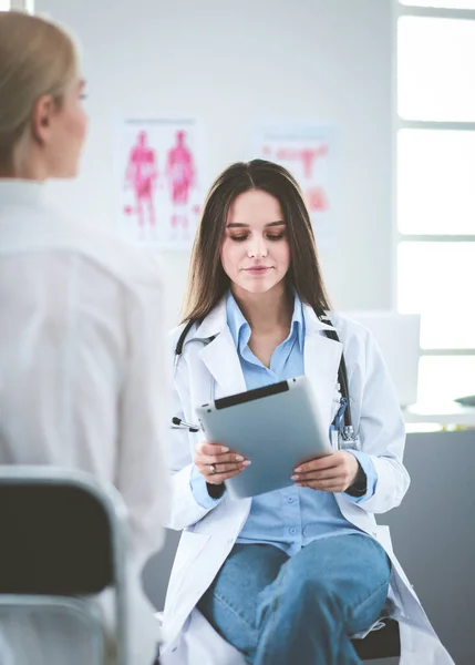 Arzt und Patient diskutieren etwas, während sie am Tisch sitzen. Medizin und Gesundheitskonzept — Stockfoto