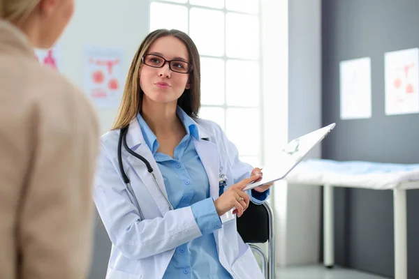 Dottore e paziente discutono di qualcosa mentre sono seduti al tavolo. Medicina e concetto di assistenza sanitaria — Foto Stock