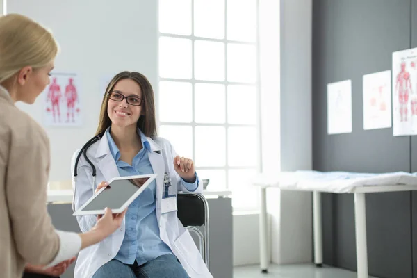 Médico e paciente discutindo algo enquanto se senta na mesa. Conceito de medicina e cuidados de saúde — Fotografia de Stock