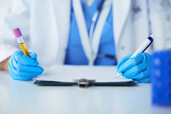 Woman researcher is surrounded by medical vials and flasks, isolated on white background — Stock Photo, Image