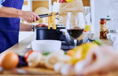 Adam ev mutfağında lezzetli ve sağlıklı yemekler hazırlıyor.