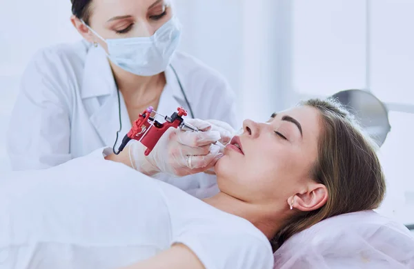 A young girl having red lips permanent makeup, micropigmentation — Stock Photo, Image