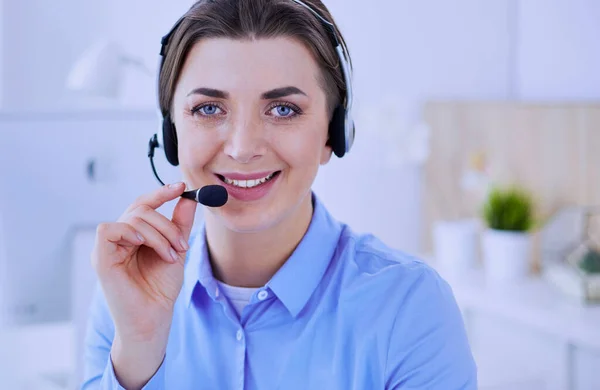 Grave bella giovane donna che lavora come operatore telefonico di supporto con auricolare in ufficio — Foto Stock