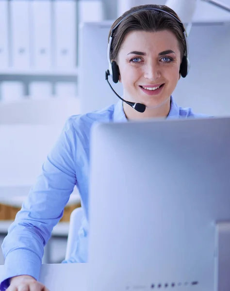 Ernstige mooie jonge vrouw die werkt als support telefoon operator met headset in het kantoor — Stockfoto