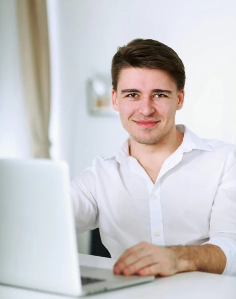 Jóképű fiatalember ül és dolgozik laptop számítógép — Stock Fotó