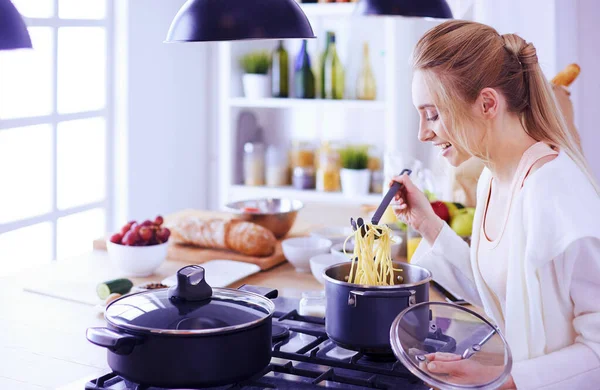 Gyönyörű fiatal nő főzés a konyhában otthon — Stock Fotó