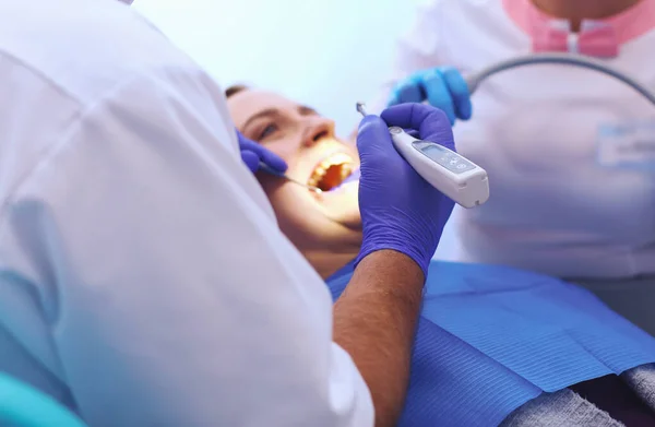 Portrait of a dentist who treats teeth of young woman patient — Stock Photo, Image