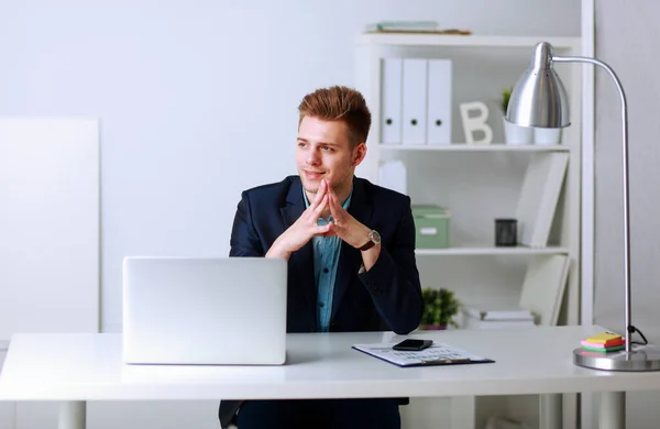 Handsome young man sitting and working on laptop computer — Stock Photo, Image