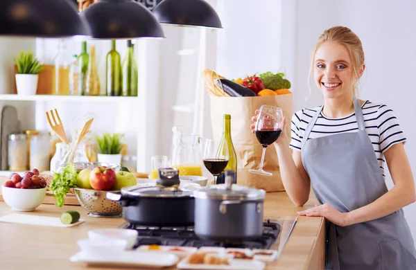 Hübsche Frau trinkt zu Hause Wein in Küche — Stockfoto