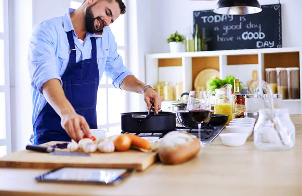 Uomo che prepara cibo delizioso e sano nella cucina di casa — Foto Stock