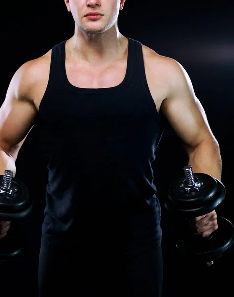 暗い背景に重りを持ち上げる筋肉質の若い男の閉鎖 — ストック写真