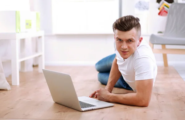 英俊的年轻人坐在笔记本电脑上工作 — 图库照片