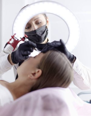 Mikro patenli kaşlar güzellik salonunda çalışır. Kaşları renkli bir kadın.