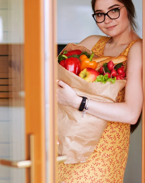 Young woman holding grocery shopping bag with vegetables — Stock Photo, Image