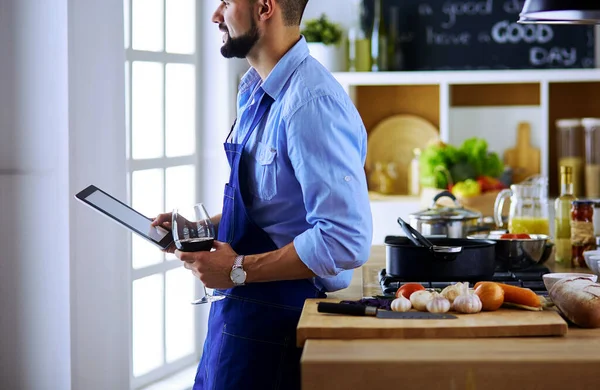 Man efter recept på digital tablett och matlagning välsmakande och hälsosam mat i köket hemma — Stockfoto
