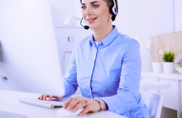 Seriös söt ung kvinna som arbetar som support telefonoperatör med headset i ämbetet — Stockfoto