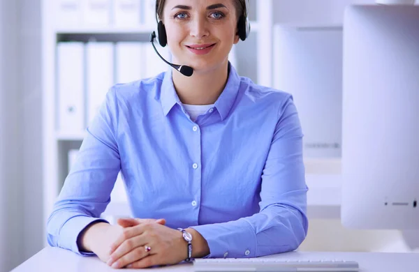 Ernsthafte hübsche junge Frau arbeitet als Telefonistin mit Headset im Büro — Stockfoto