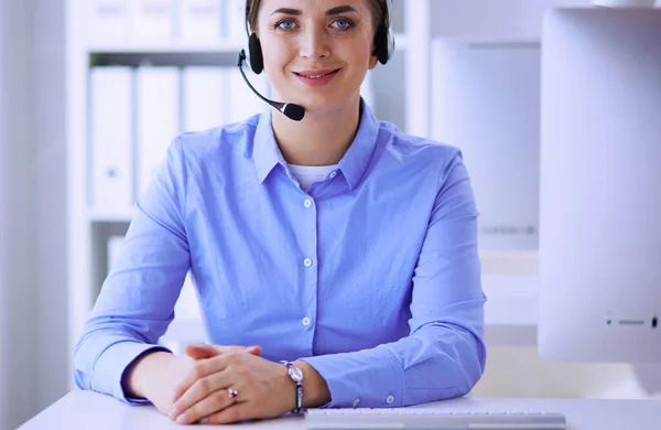 Mujer bastante joven y seria que trabaja como operador de telefonía de apoyo con auriculares en la oficina — Foto de Stock