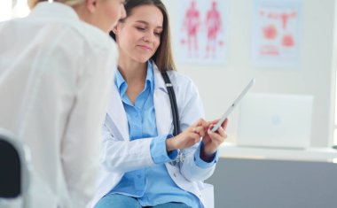 Doktor ve hasta masada otururken bir şey tartışıyorlar. İlaç ve sağlık hizmetleri kavramı