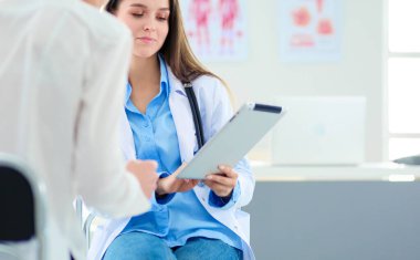 Doktor ve hasta masada otururken bir şey tartışıyorlar. İlaç ve sağlık hizmetleri kavramı