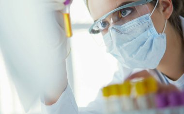 Hastanedeki kan örneğini analiz eden güzel bir kadın laboratuvar asistanı portresi.