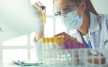 Modern laboratuvar veya hastanede plastik tıbbi tüplerle çalışan araştırmacı, doktor, bilim adamı veya laboratuvar asistanı