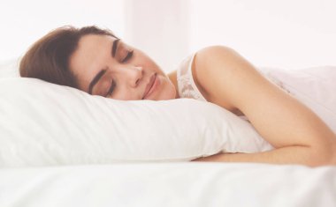Güzel bir kadın yatağında uzanıyor.