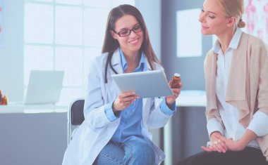 Doktor ve hasta masada otururken bir şey tartışıyorlar. İlaç ve sağlık hizmetleri kavramı