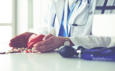 Masada kırmızı kalbi ve steteskopu olan kardiyolog.