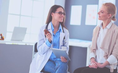 Doktor ve hasta masada otururken bir şey tartışıyorlar. İlaç ve sağlık hizmetleri kavramı