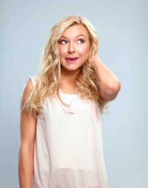 Gri arka planda soyutlanmış genç, duygusal bir kadın.