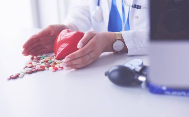 Masada kırmızı kalbi ve steteskopu olan kardiyolog.