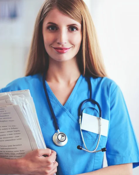 La doctora está parada en la ventana cercana. — Foto de Stock