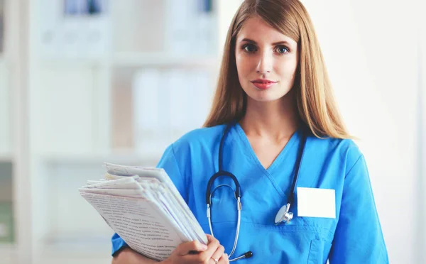 La doctora está parada en la ventana cercana. — Foto de Stock