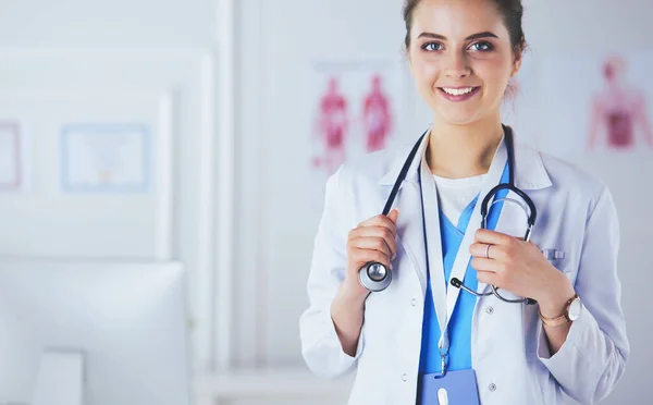 Retrato de una joven doctora con una bata blanca de pie en el hospital — Foto de Stock