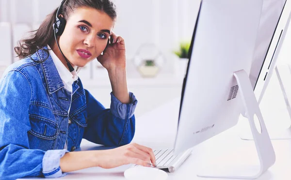 Retrato de una hermosa mujer de negocios trabajando en su escritorio con auriculares y portátil —  Fotos de Stock