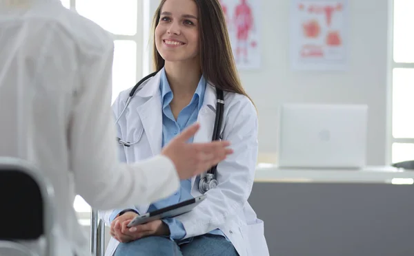 Doktorn och patienten diskuterar något när de sitter vid bordet. Medicin och hälsovård — Stockfoto