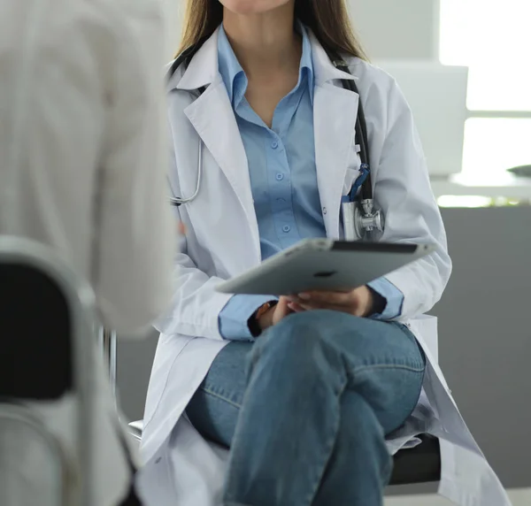 Dokter en patiënt bespreken iets terwijl ze aan tafel zitten. Begrip "geneeskunde en gezondheidszorg" — Stockfoto