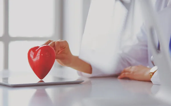 Steteskop tutan, kalbi hafif arka planda olan kadın bir doktor. — Stok fotoğraf