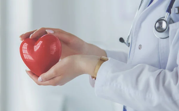 심장을 들고 있는 청진기를 가지고 있는 여자 의사, 밝은 배경 — 스톡 사진