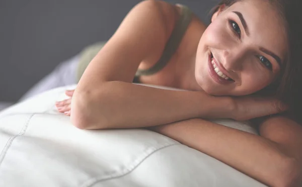 Gros plan d'une jeune femme souriante allongée sur le canapé — Photo