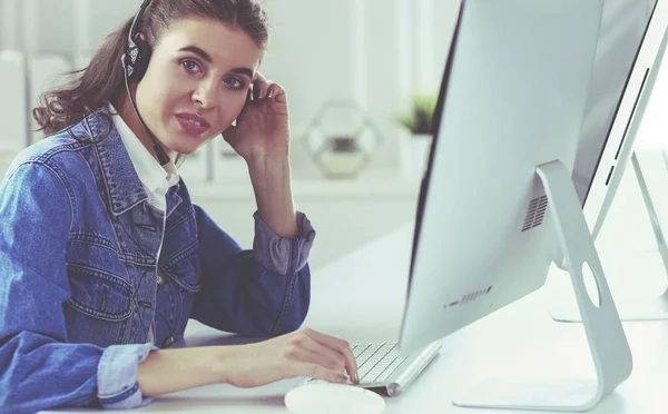 Portrait of beautiful business woman working at her desk with headset and laptop — Stock Photo, Image