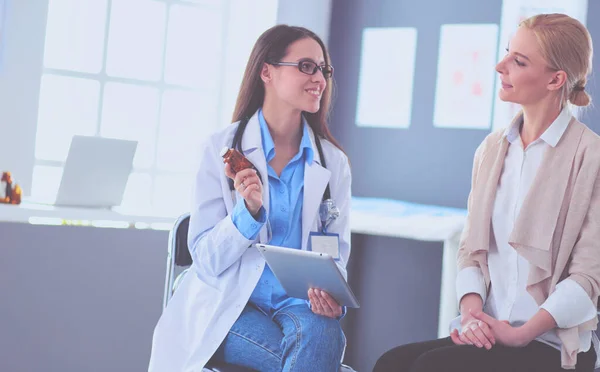 Docteur et patient discutant de quelque chose assis à la table. Médecine et soins de santé concept — Photo