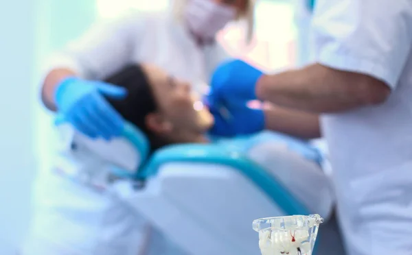 Retrato de un dentista que trata los dientes de una paciente joven — Foto de Stock