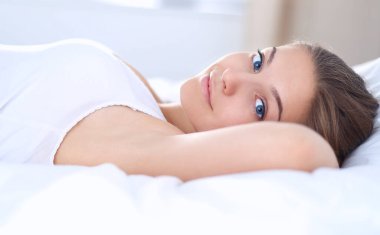 Yatakta rahat ve mutlu bir şekilde yatan güzel bir genç kadın.